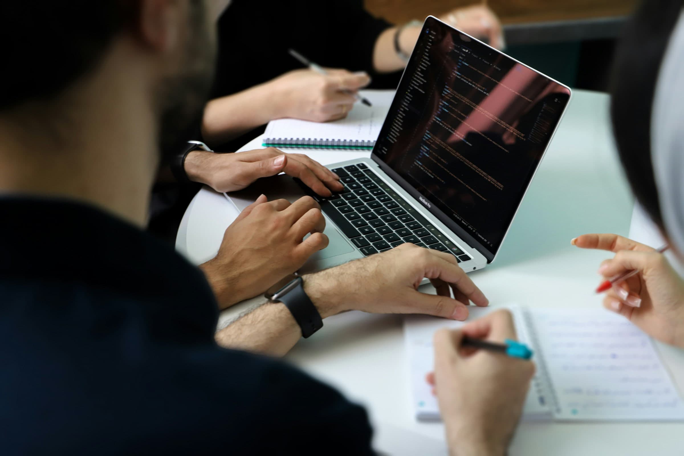 A small group working together over a laptop